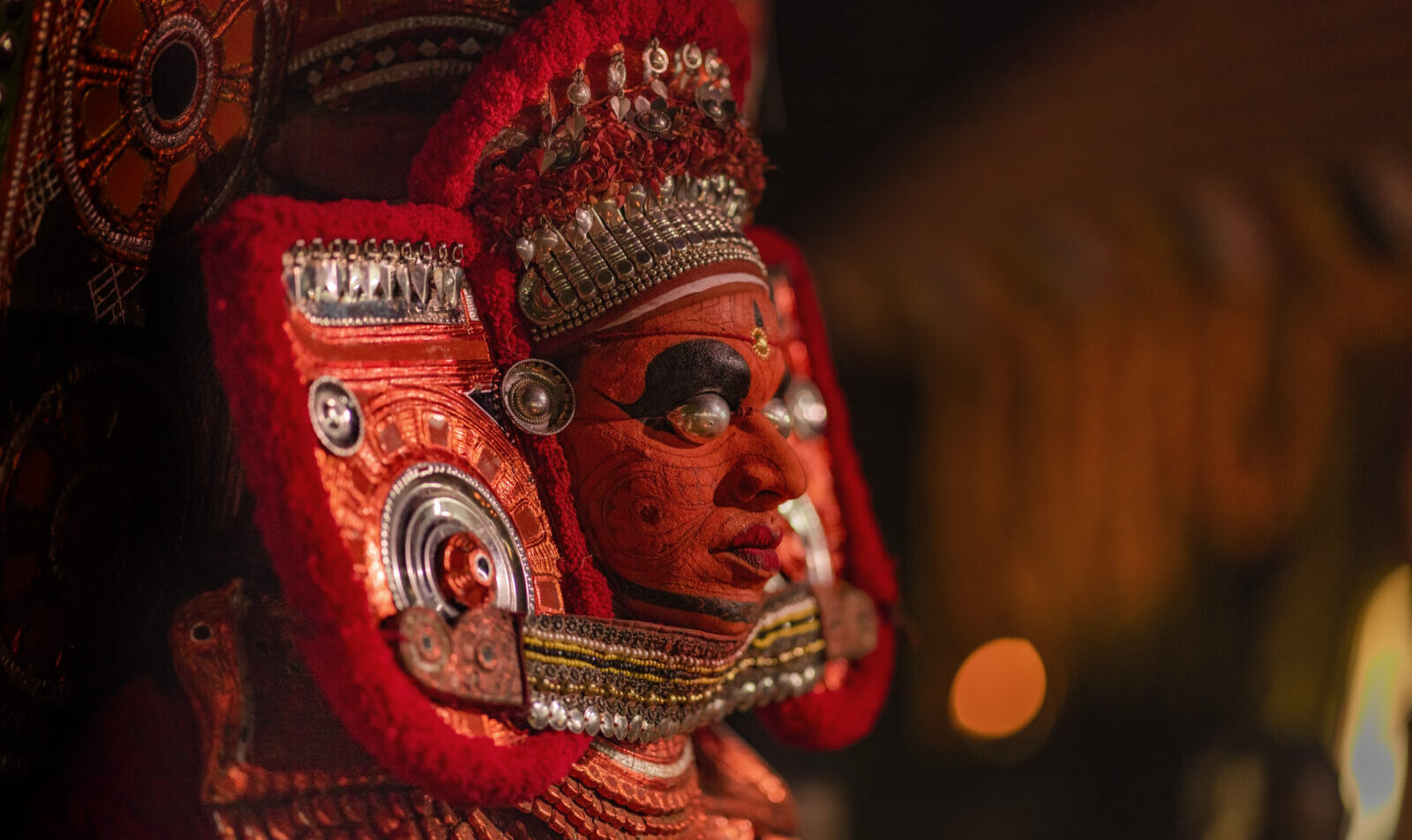 Side view of man wearing theyyam costume as form of dance worshi